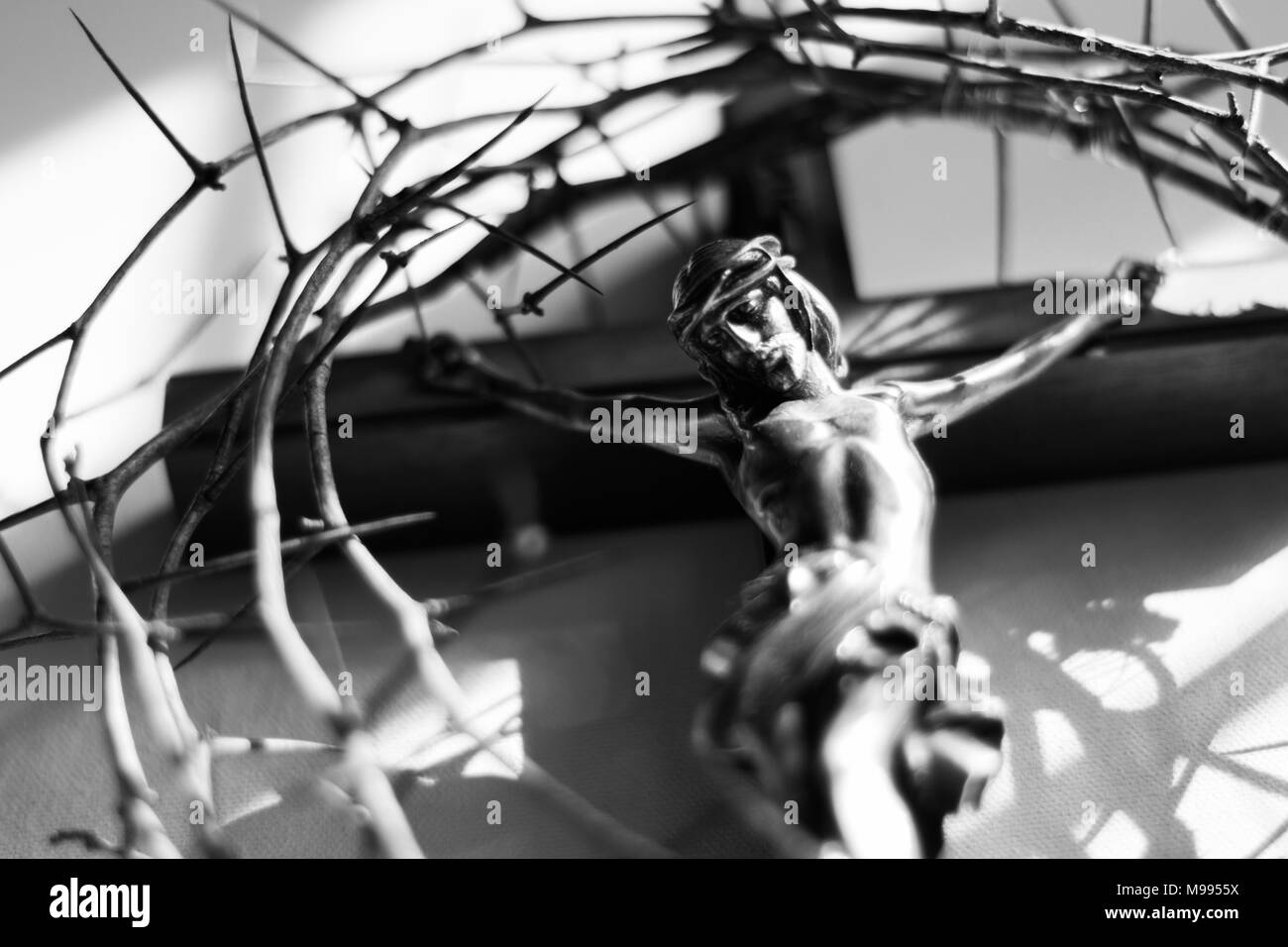 Couronne d'épines et crucifix dans l'éclairage dramatique. Banque D'Images