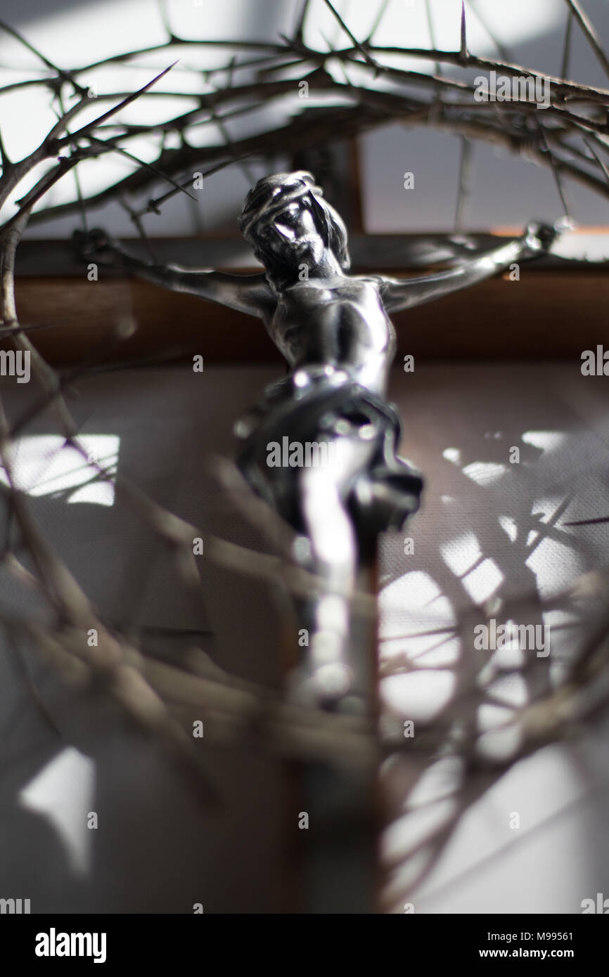 Couronne d'épines et crucifix dans l'éclairage dramatique. Banque D'Images