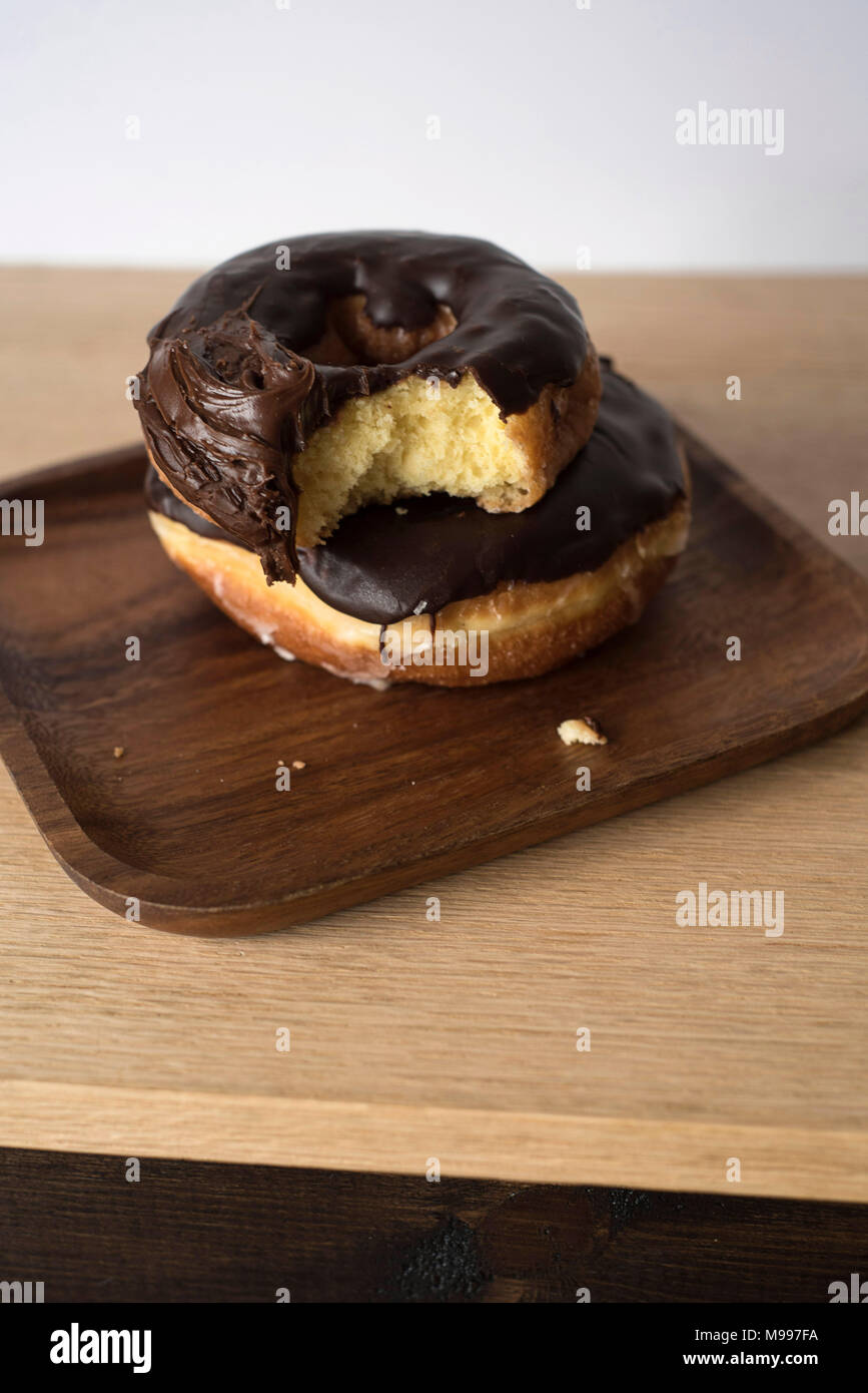 Donuts empilés avec une morsure hors de l'une sur un fond clair Banque D'Images