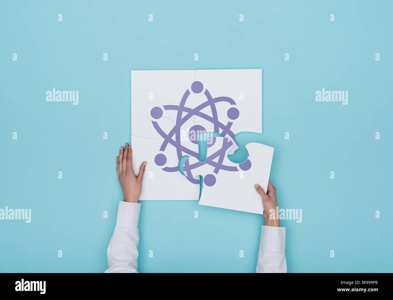 Femme de remplir un puzzle avec l'icône de l'atome, elle met la pièce manquante, la physique et la science concept Banque D'Images