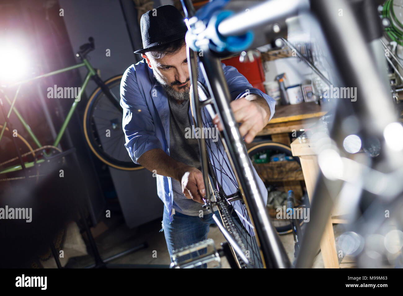 Man working on bicycle in workshop Banque D'Images