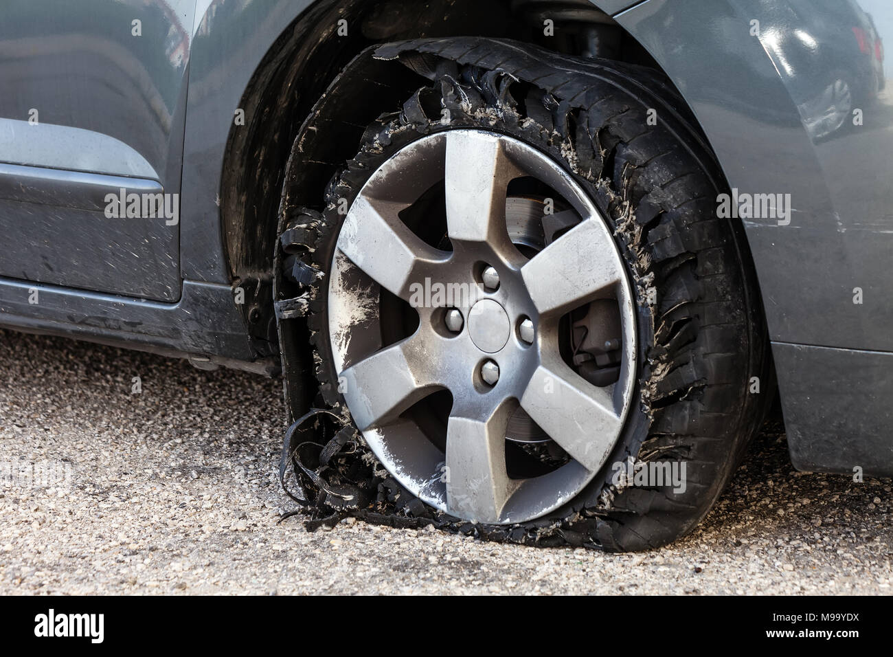 Détruit en épingle avec des pneus déchiquetés, éclatée et caoutchouc endommagé sur un suv moderne automobile. Des pneus à profil plat sur une jante en alliage, éventré Banque D'Images