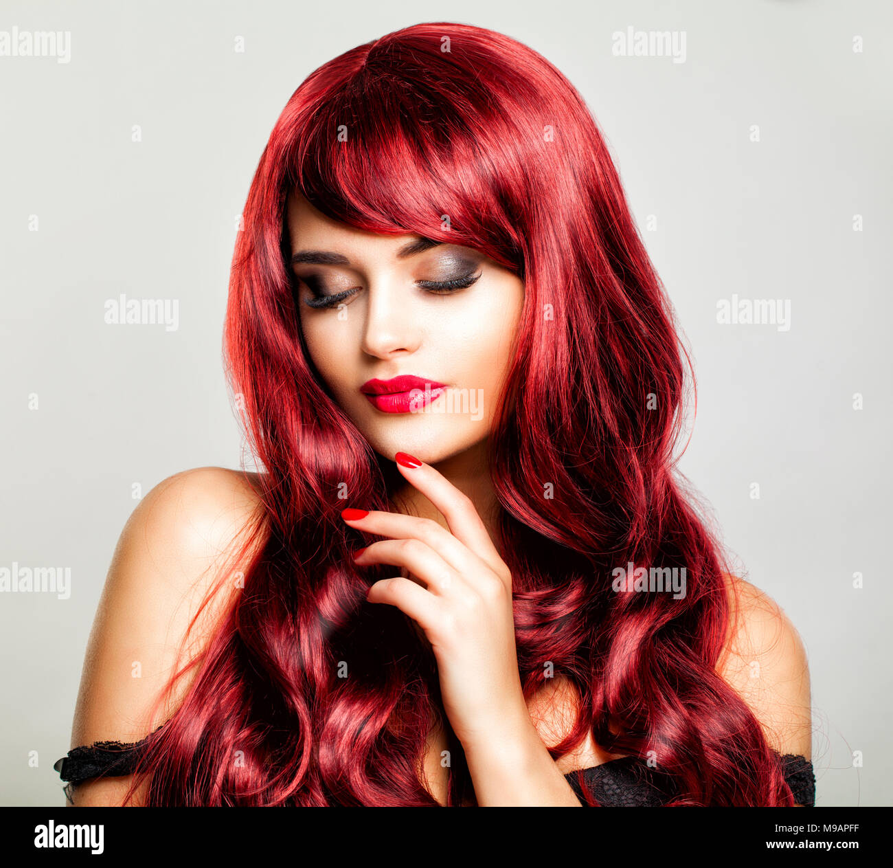 Jeune femme à la mode des cheveux bouclés. Heureux Redhead modèle avec un miroir Banque D'Images