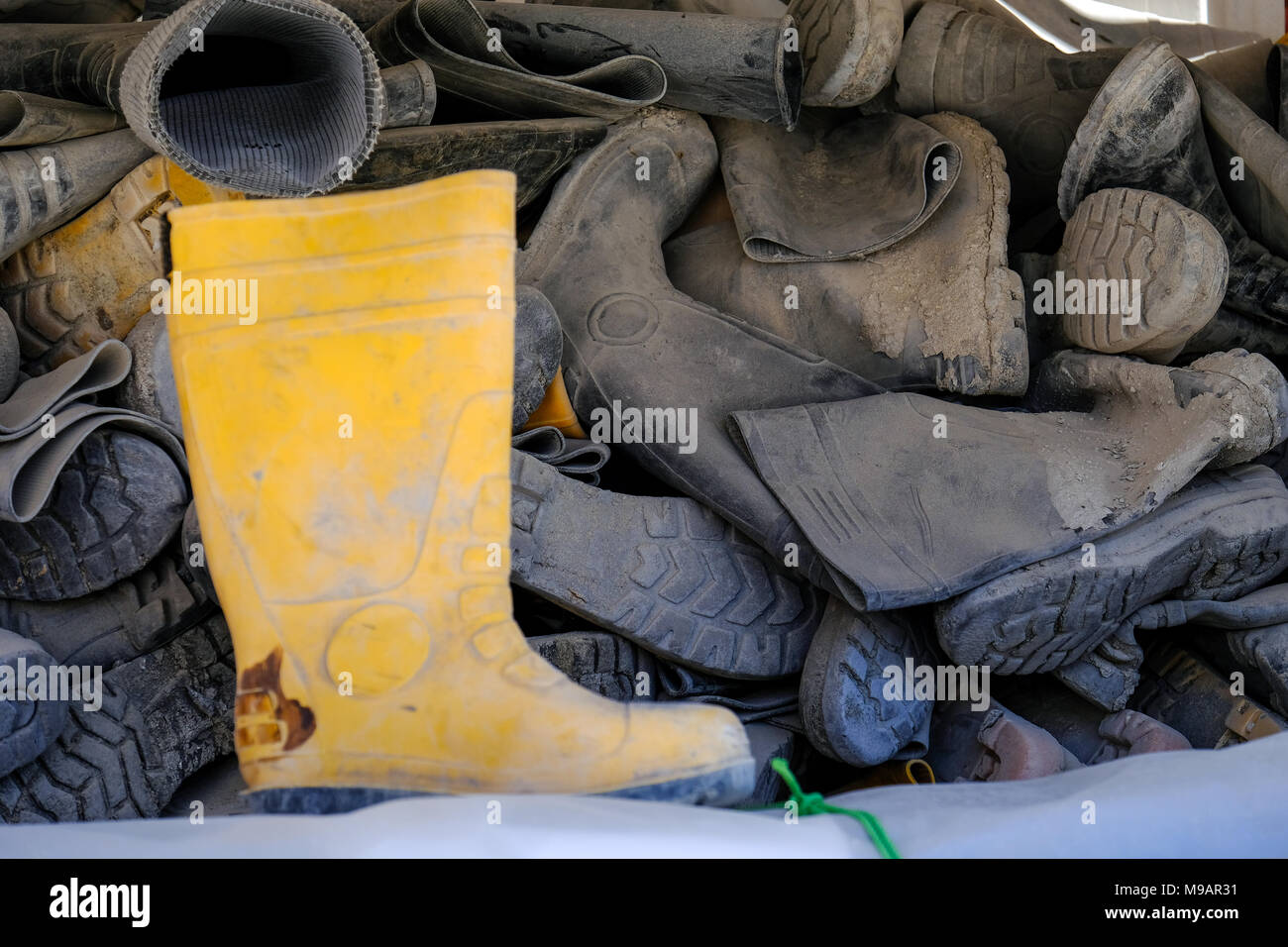 Bottes de gomme utilisée accumulée empilés dans l'extérieur de rack Banque D'Images