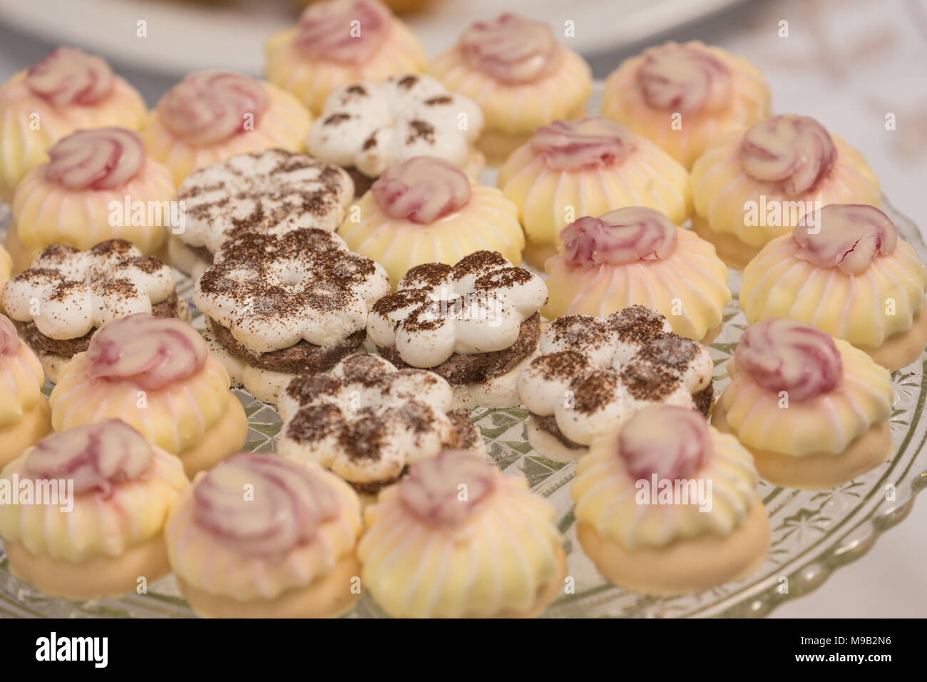 Des gâteaux sucrés avec du glaçage sur un plateau Banque D'Images