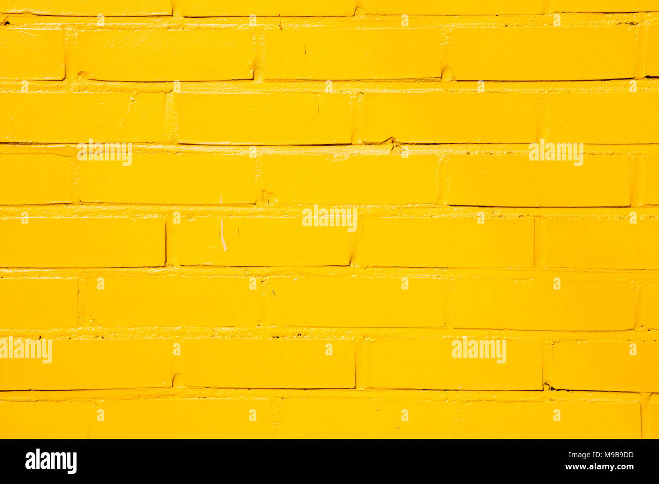 Mur de briques peint jaune background Banque D'Images