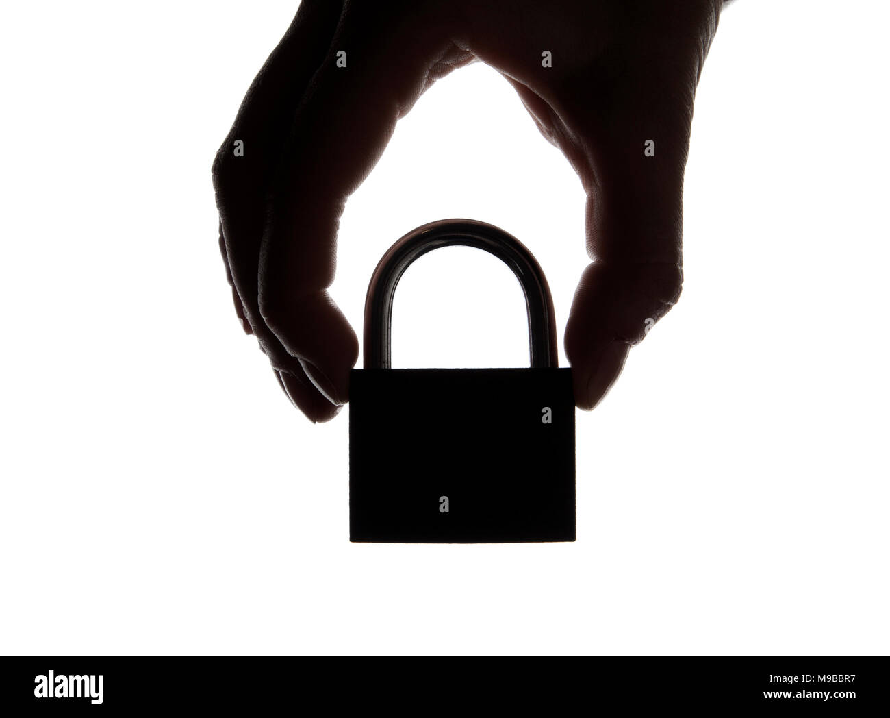 Silhouette d'une main tenant un cadenas sur un arrière-plan uni, blanc. Sécurité et confidentialité. Banque D'Images