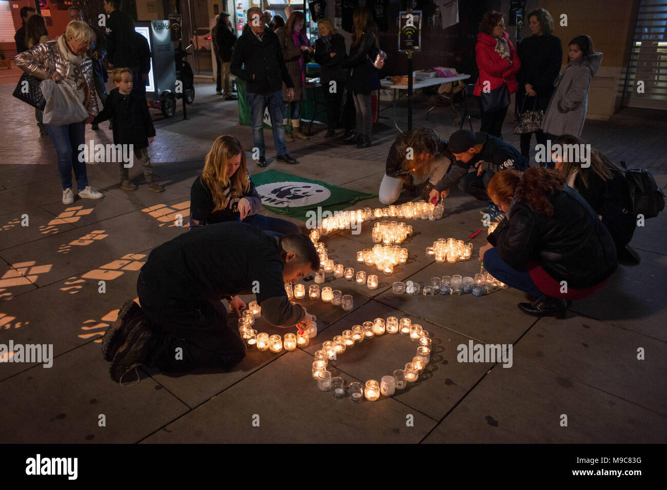 Malaga, Espagne. 24Th Mar, 2018. Les membres de la World Wildlife Fund (WWF) vu les bougies d'éclairage au cours de l'heure de la Terre dans le centre-ville de Malaga. La figure avec des bougies représente un panda, le symbole du WWF.Des milliers de villes à travers le monde éteint les lumières électriques pour mettre en garde contre les dangers du changement climatique au cours de la '' 'Terre Heure Crédit : Jésus Merida/SOPA Images/ZUMA/Alamy Fil Live News Banque D'Images