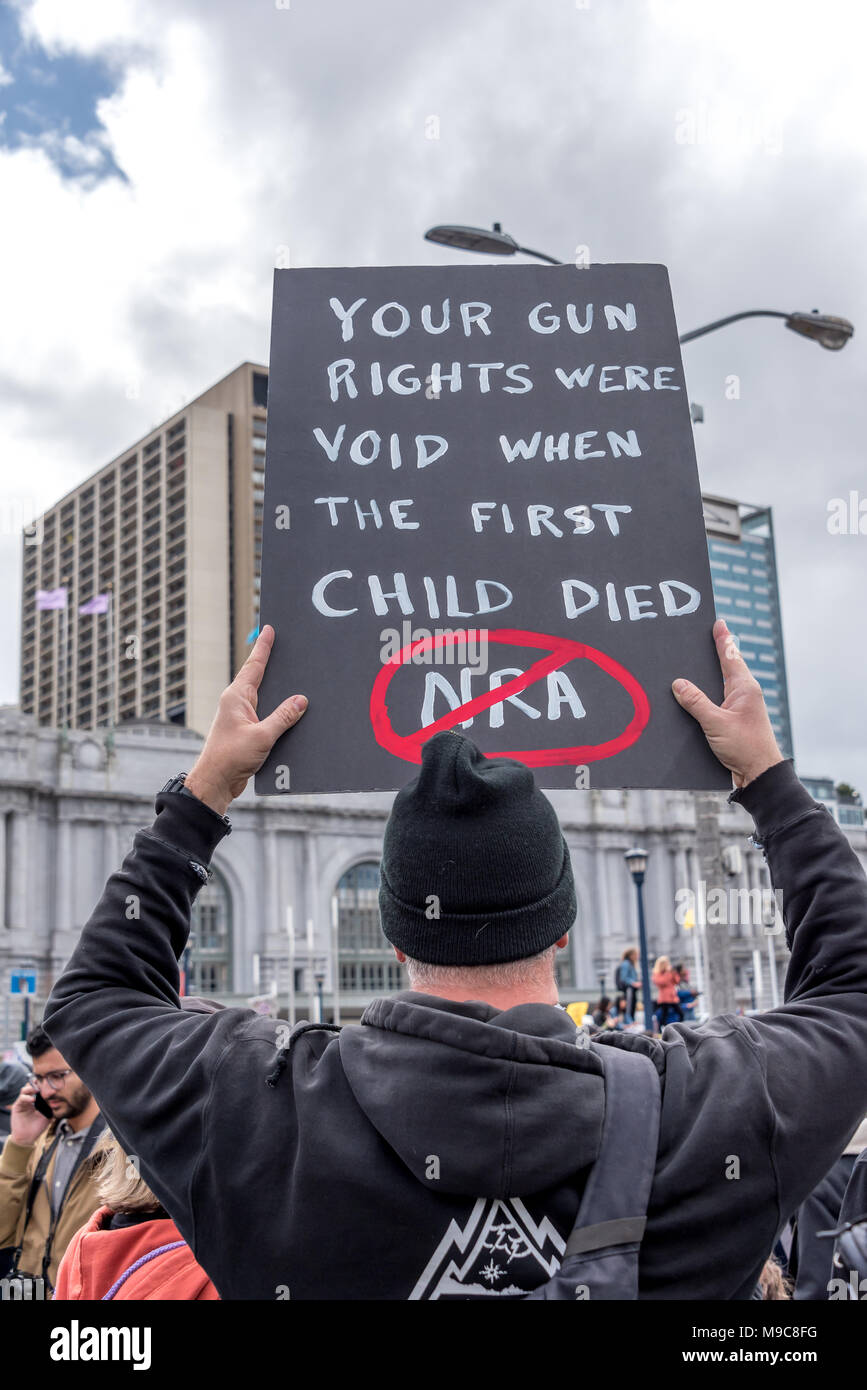 San Francisco, USA. 24 mars, 2018. Mars pour notre vie rallye et mars à appeler pour le contrôle des armes et de fin de la violence par arme à feu, un homme en noir est titulaire d'un panneau noir lecture, 'votre arme de l'homme sont sans effet lorsque le premier enfant est mort", avec un cercle rouge barré sur 'ARN'. Shelly Rivoli/Alamy Live News Banque D'Images