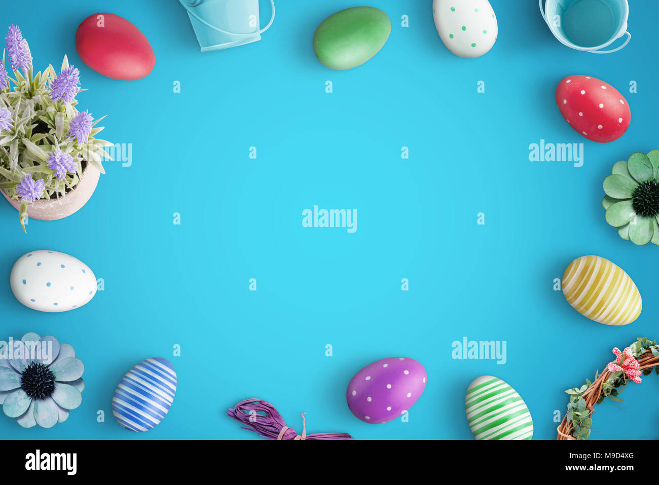 Oeufs colorés de Pâques sur bleu 24. Copie de l'espace dans le milieu pour le texte. Vue d'en haut. Banque D'Images