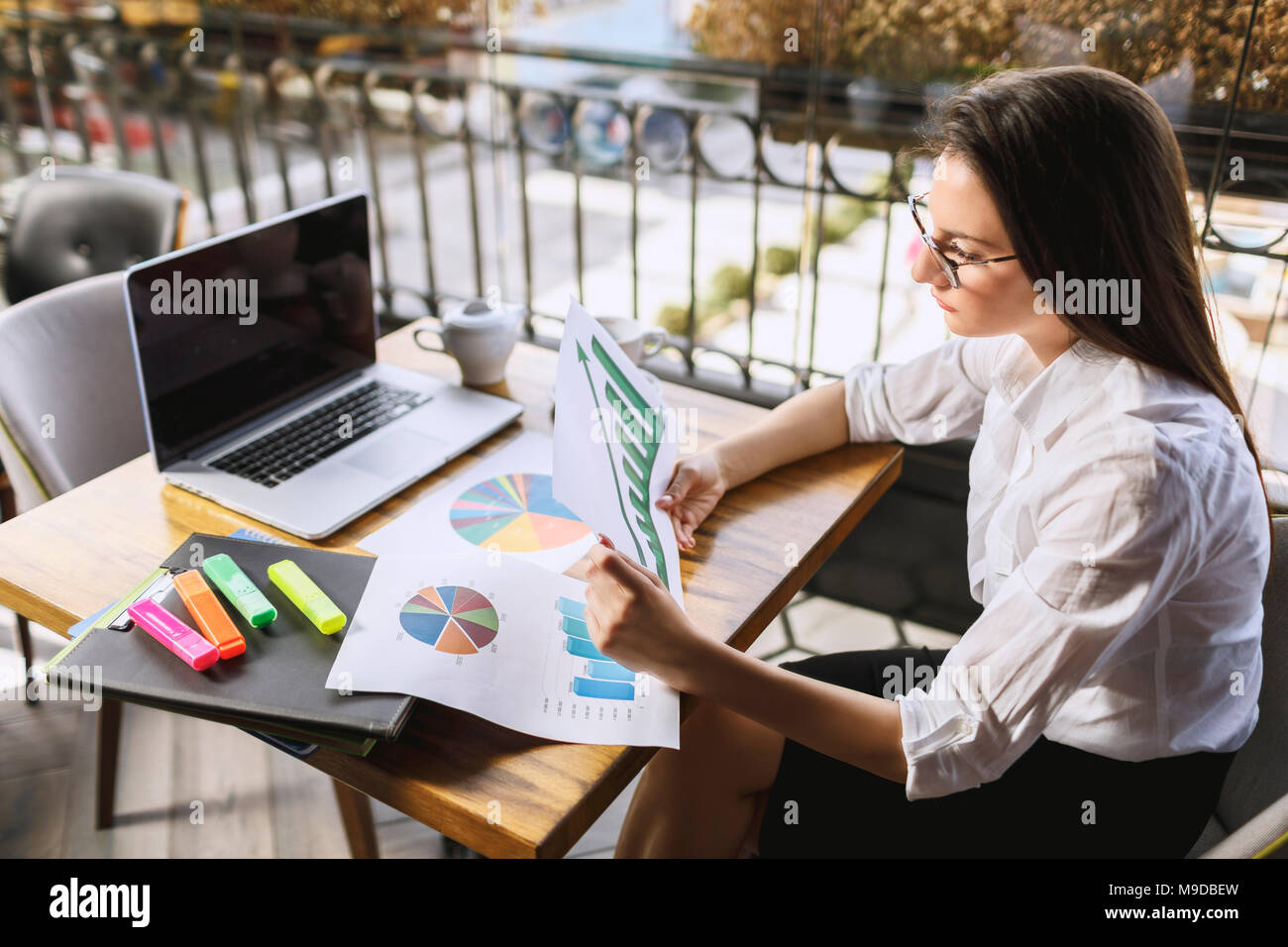 Businesswoman ou jeune femme avec des lunettes travaillant sur des documents et ordinateur portable. Banque D'Images