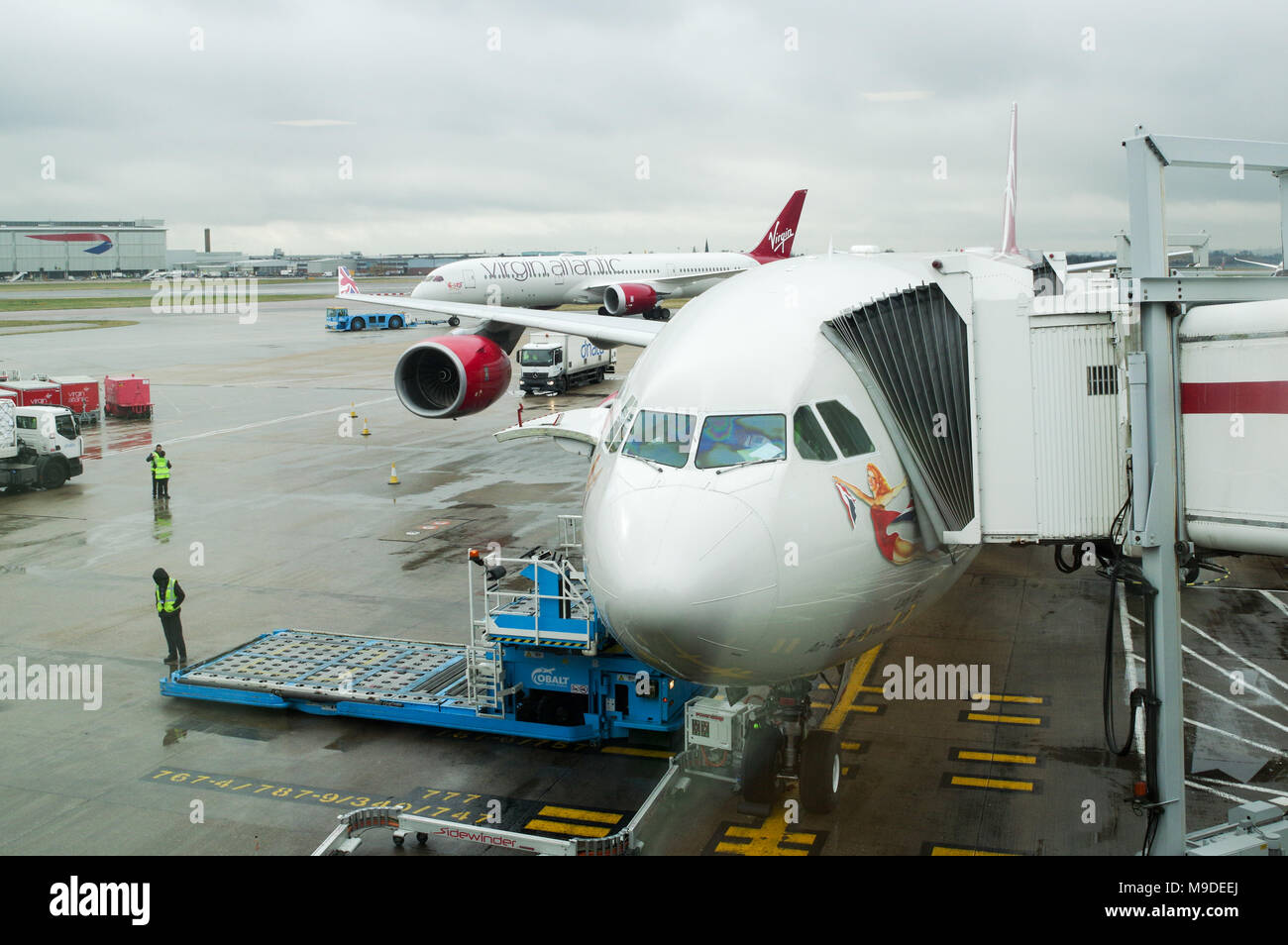 Virgin Atlantic Airbus A340 la préparation pour le départ alors qu'un Boeing 787 Virgin passe en arrière-plan à l'aéroport Heathrow de Londres Banque D'Images