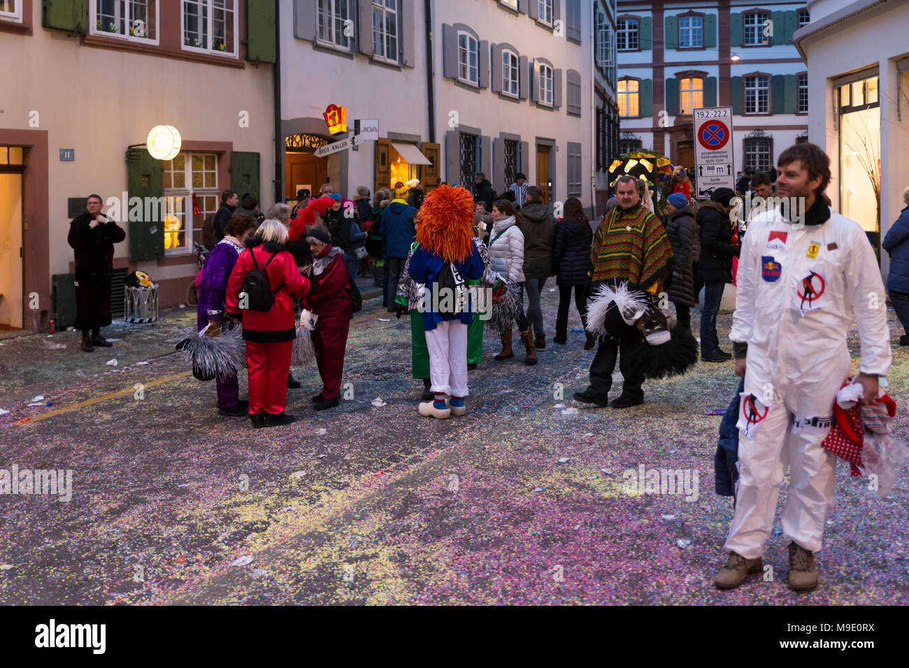 Baeumleingasse, Bâle, Suisse - 20 février 2018. Carnaval de Bâle. Carnaval animé la vie dans une rue latérale couverte de confettis colorés Banque D'Images