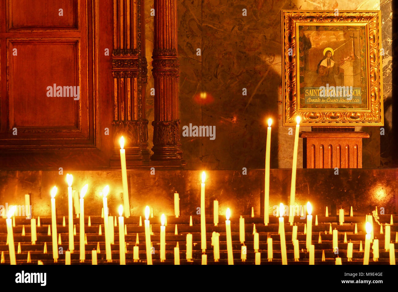 Bougies devant l'icône de Sainte Rita de Cascia, patronne des causes perdues et impossible, dans l'église de La Madeleine à Paris Banque D'Images