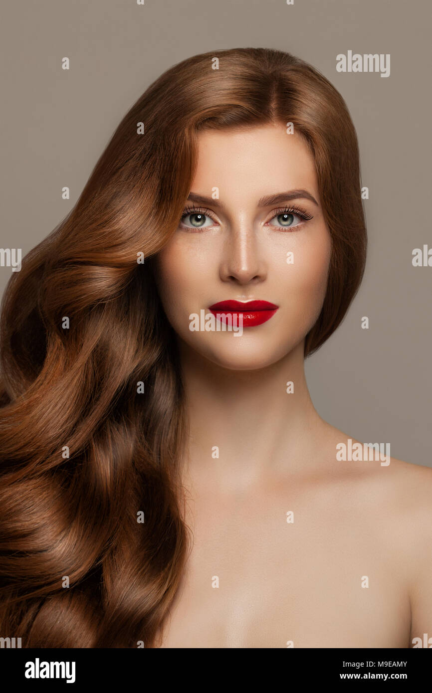 Femme élégante rouge avec les cheveux bouclés. Modèle rousse mignon, joli visage Banque D'Images