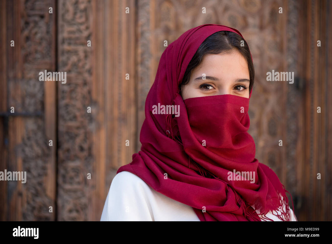 Portrait de jeune femme musulmane avec foulard hijab rouge sur son visage Banque D'Images