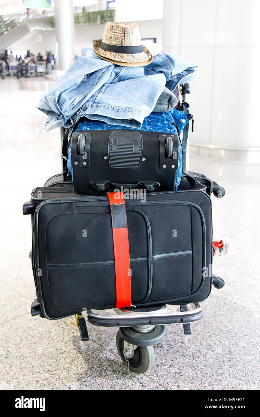 Une pile de bagages sur un chariot à l'aéroport. Valise trolley chargé sur  le stand, dans le hall Photo Stock - Alamy