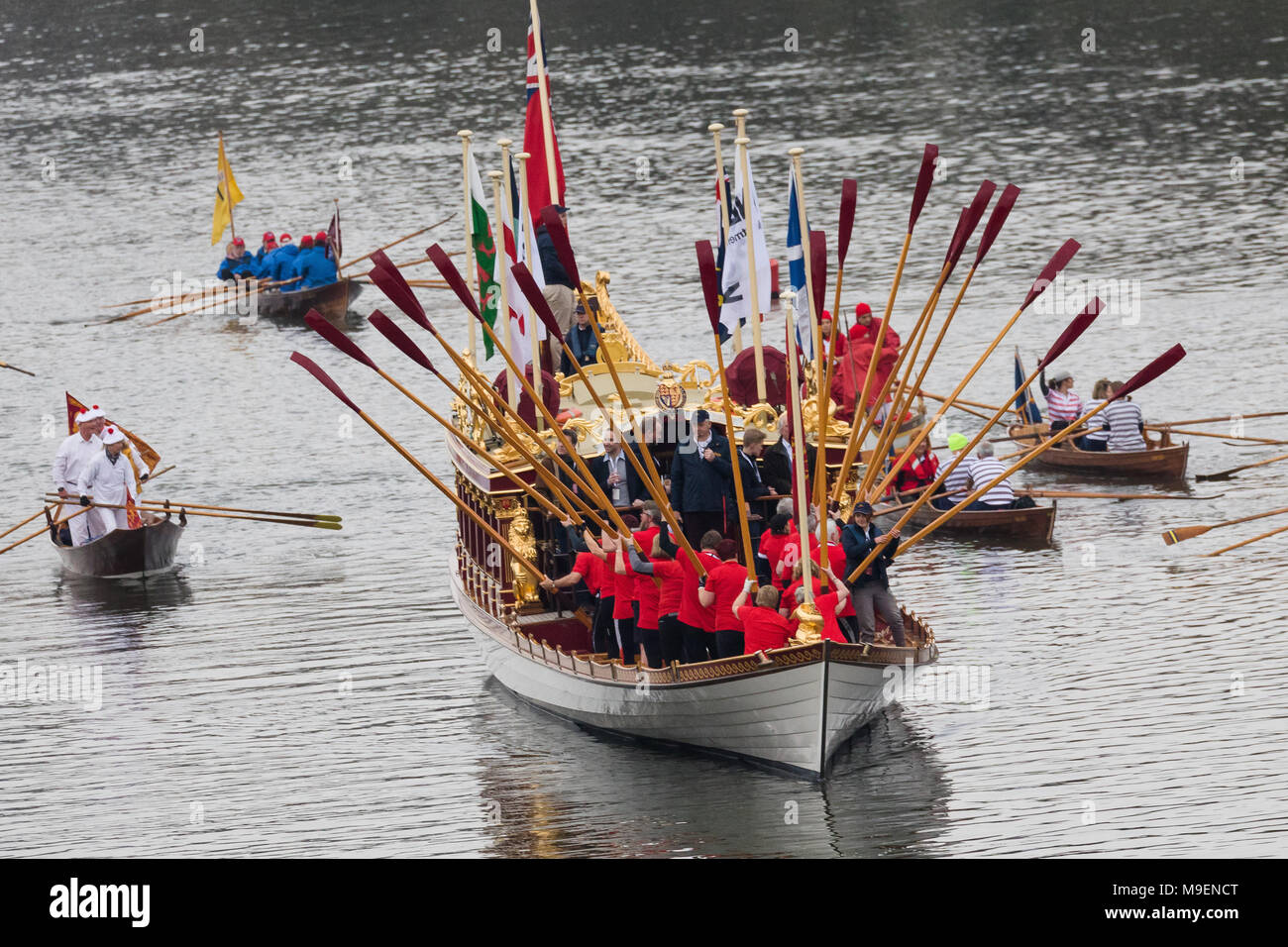 Londres, Royaume-Uni. Le 24 mars 2018. Gloriana, le Queen's row barge, escorté par une flottille de bateaux aviron traditionnel de l'ensemble de l'Europe mène la voile Race Festival de l'aviron sur la Tamise près de Mortlake. La flottille de bateaux le bateau de ligne avant la course les courses importantes entre les universités de Cambridge et Oxford. Credit : Londres Vickie Flores/Alamy Live News Banque D'Images