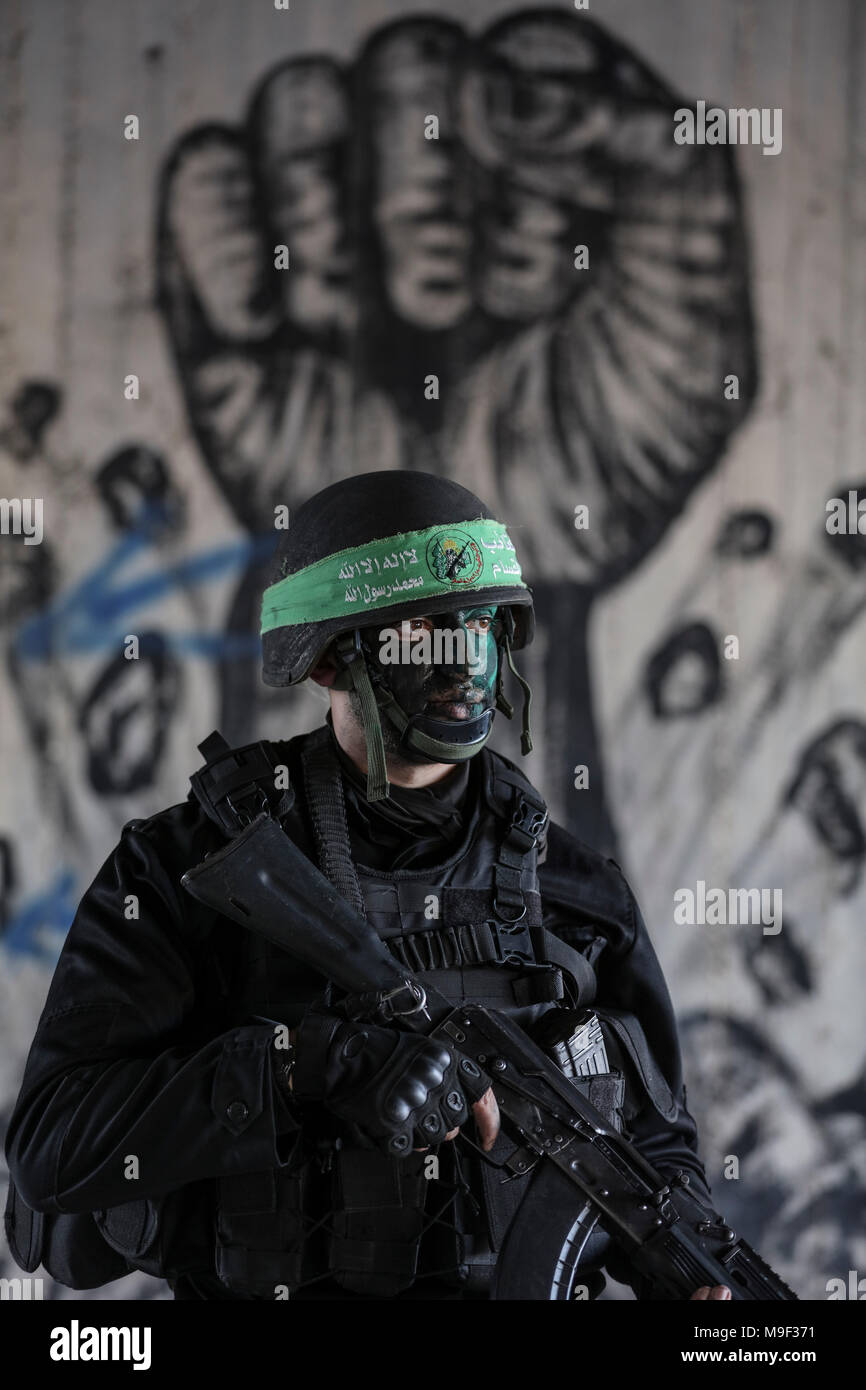 Dpatop - un militant d'Izz ad-Din al-Qassam, la branche militaire du mouvement islamiste palestinien Hamas, monte la garde lors d'un forage à grande échelle à l'extérieur de la ville de Gaza, bande de Gaza, le 25 mars 2018. Photo : Wissam Nassar/dpa Banque D'Images