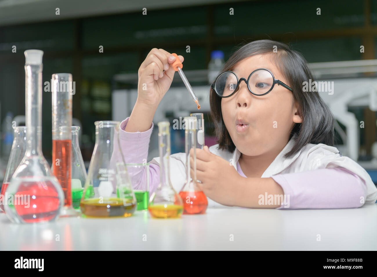 Petite fille excité in lab coat faire expérimenter avec tube à essai en  laboratoire de chimie, de la science et de l'éducation concept Photo Stock  - Alamy