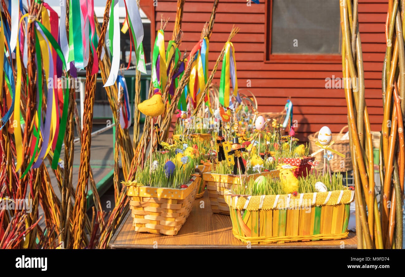 Souvenirs traditionnels affiche sur la table au cours de la rue du marché de Pâques. Des paniers en bois vert avec les jeunes pousses de céréales, œufs de Pâques, les figures de l'Orient Banque D'Images