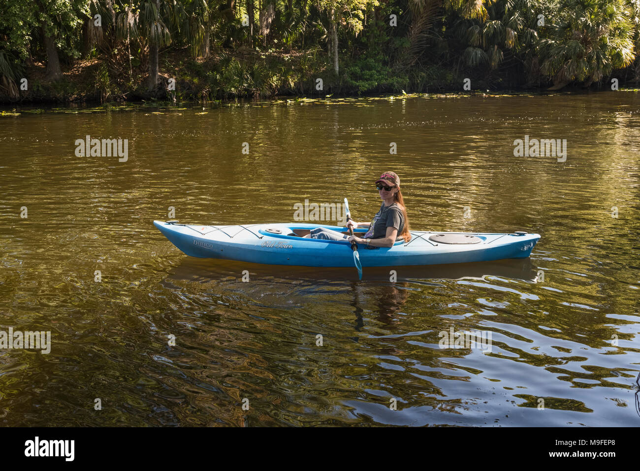 Cheveux rouge attrayante femme kayak les haines Creek River dans la région de Lake County en Floride. Banque D'Images