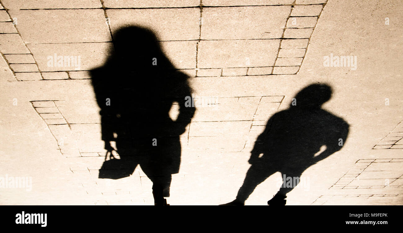 Ombre Silhouette d'une femme et un homme sur le trottoir de la ville en sépia Noir et blanc Banque D'Images
