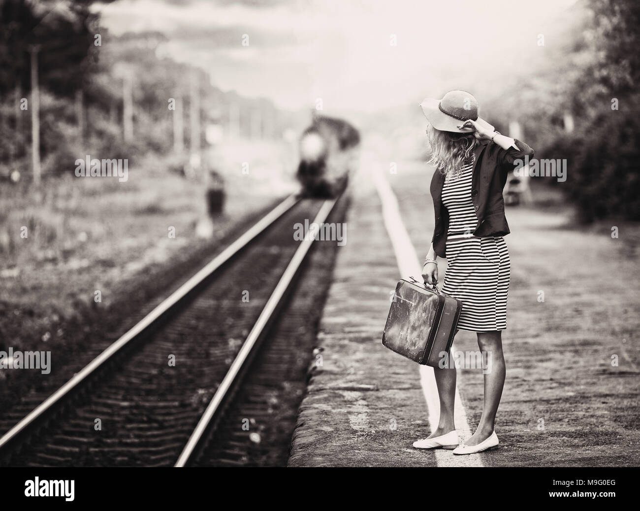 La femme est en attente d'un train à vapeur Banque D'Images