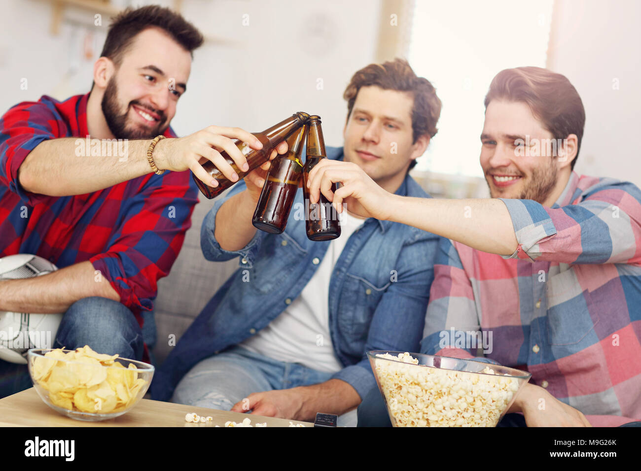 Photo de heureux amis acclamations et regarder du sport à la télévision Banque D'Images