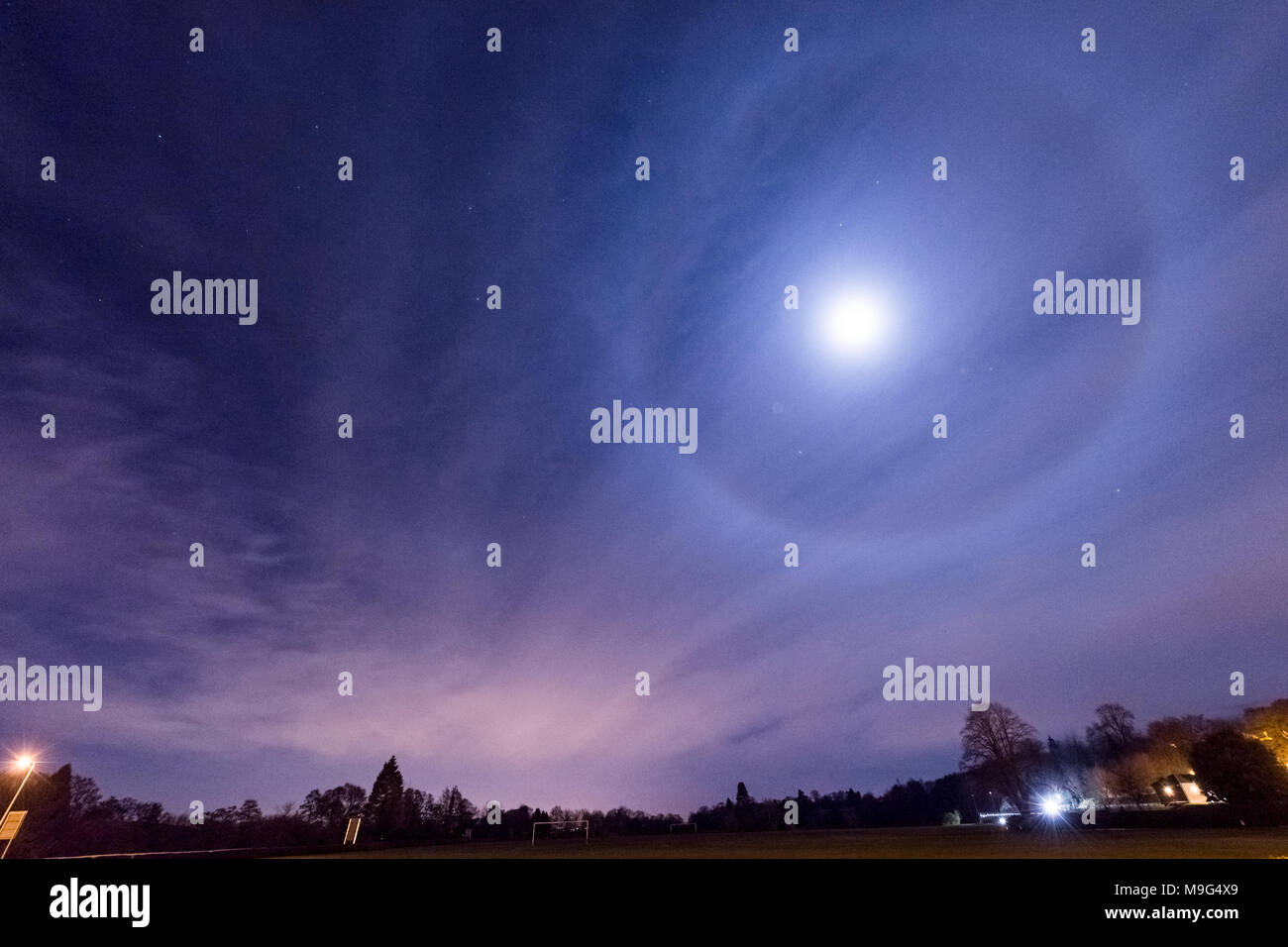 Rocester, Staffordshire, Royaume-Uni. 25 mars 2018. Météo France : la lune est vu par un 22º halo formé par des cristaux de glace, qui se réfractent la lumière de la lune, la création d'un anneau autour d'elle. Vu et pris de Rocester, Staffordshire, dans la nuit du 25 mars 2018. Crédit : Richard Holmes/Alamy Live News Banque D'Images