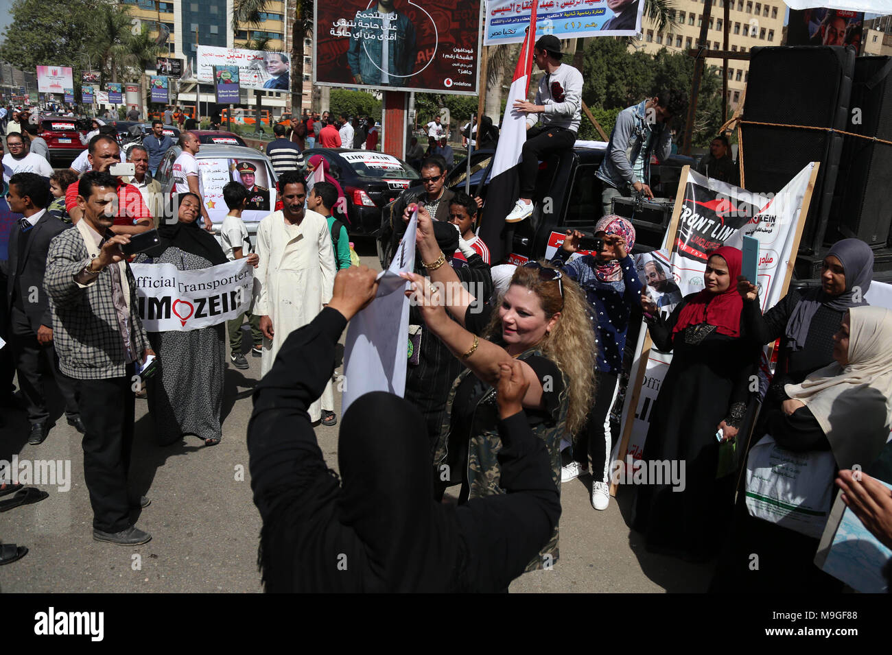 Le Caire, Égypte. Mar 26, 2018. Les Egyptiens la danse et célébrer avec une affiche électorale du Président sortant Abdel Fattah al-Sisi le premier jour de l'élection présidentielle égyptienne 2018 outsdie, un bureau de vote, au Caire, en Egypte, le 26 mars 2018. Roland-garros aux urnes dans trois jours de vote pour choisir entre le titulaire Abdel Fattah al-Sisi et candidat Moussa Mostafa Moussa Crédit : Fayed El-Geziry/APA/Images/fil ZUMA Alamy Live News Banque D'Images