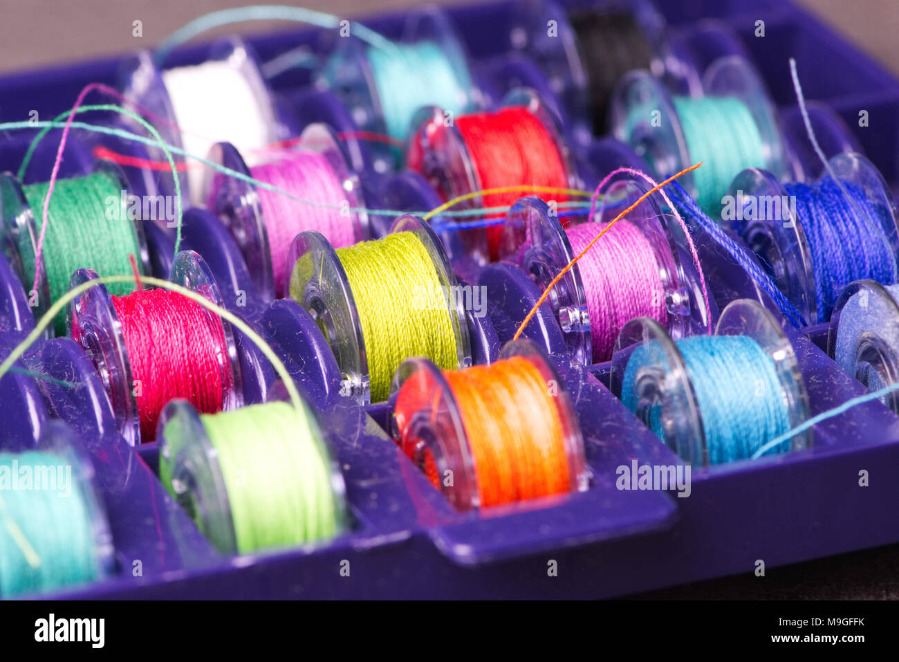 Bobines de couleur pour la couture dans une boîte en plastique violet Banque D'Images