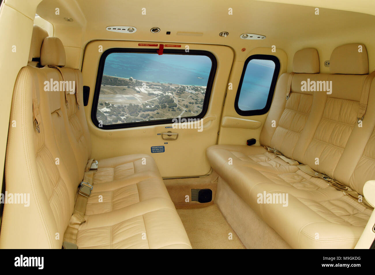 Panorama de l'intérieur d'un hélicoptère Agusta 109 avec sièges en cuir crème. Vide intérieur avec une vue montrant l'hauteur visible par windows. Banque D'Images