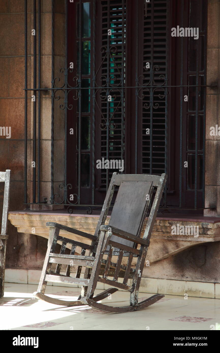Une chaise à bascule sur une véranda ensoleillée dans le centre de La Havane, Cuba. Banque D'Images