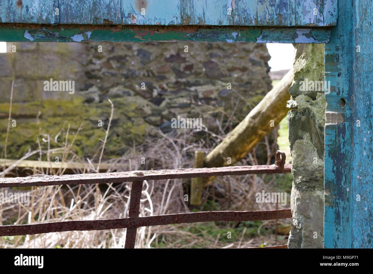 Un bâtiment de ferme à l'abandon et clôture rouillée Banque D'Images