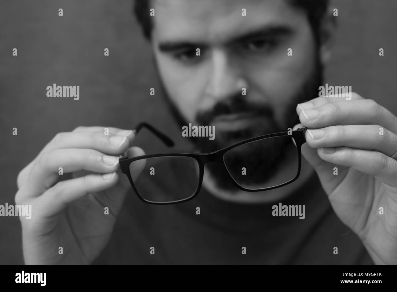 Voir par : jeune homme avec des lunettes et barbe noir et blanc portrait Banque D'Images