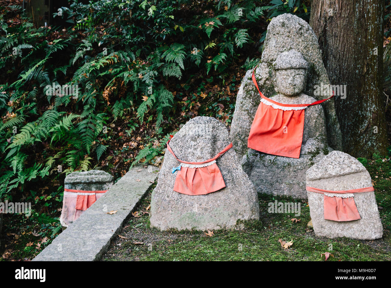 Buddha statue en pierre portant un tablier rouge au temple Kiyomizu-dera à Kyoto, Japon Banque D'Images