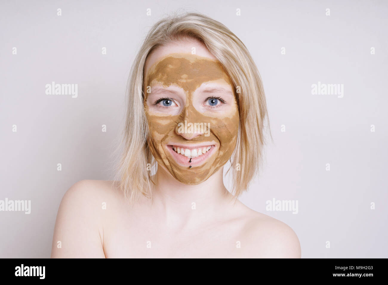 Jeune femme avec terre de guérison ou d'argile beauté facial mask Banque D'Images