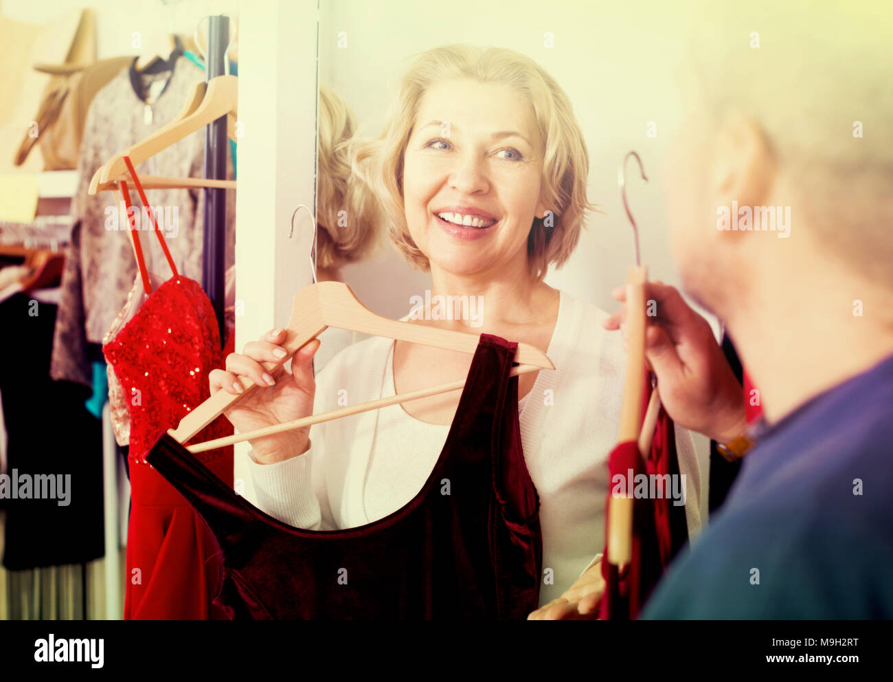 Portrait of smiling mature couple essayant sur nouvelle robe en salon d'essayage à la boutique Banque D'Images
