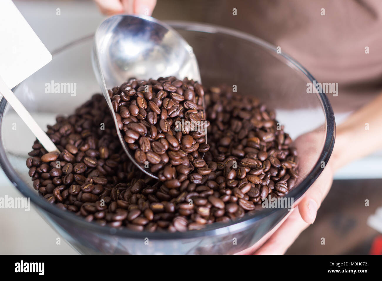 Le vendeur verse de café contenant de verre dans l'atelier. Banque D'Images