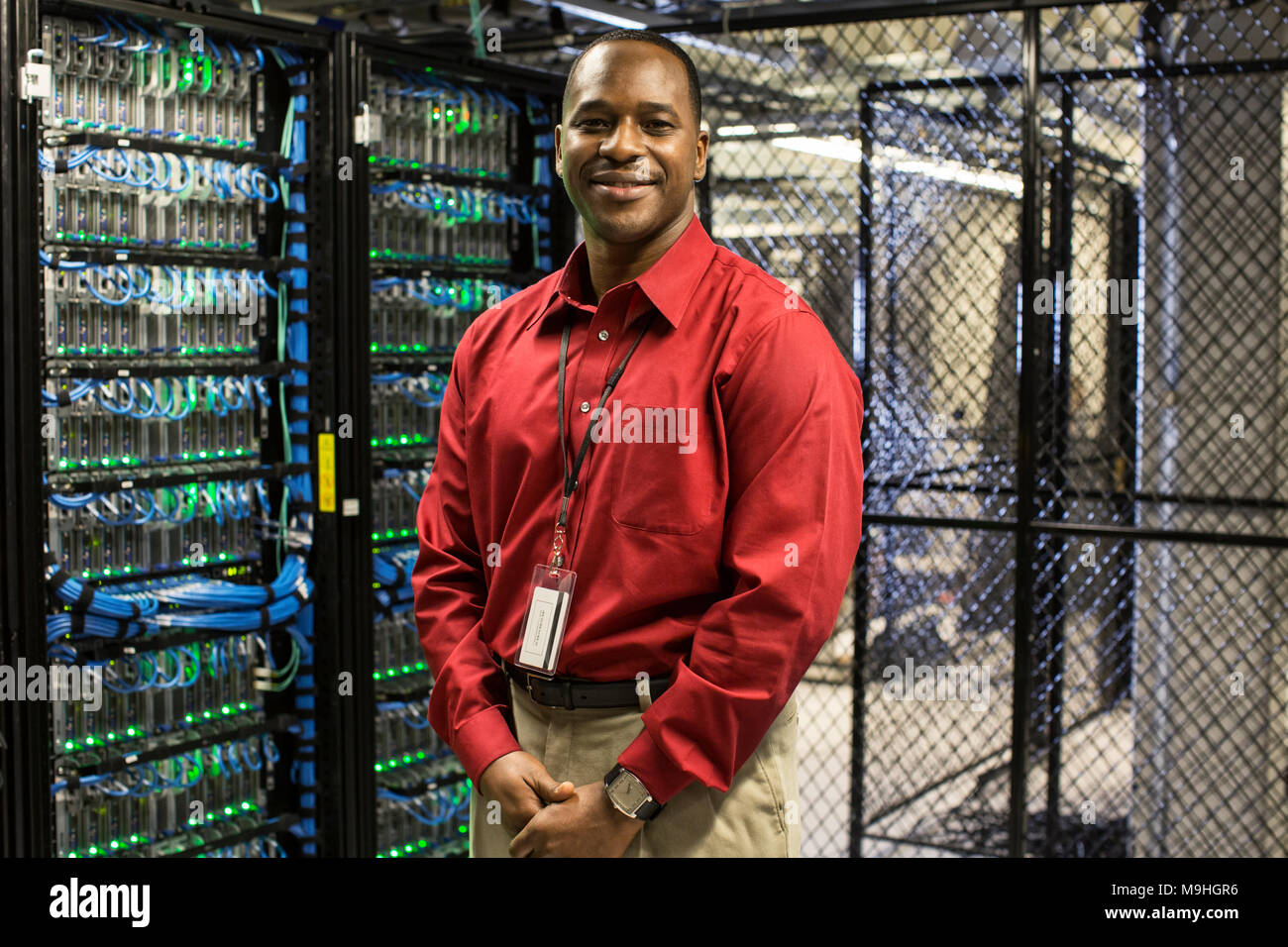 Homme noir technicien dans une batterie de serveurs informatiques. Banque D'Images