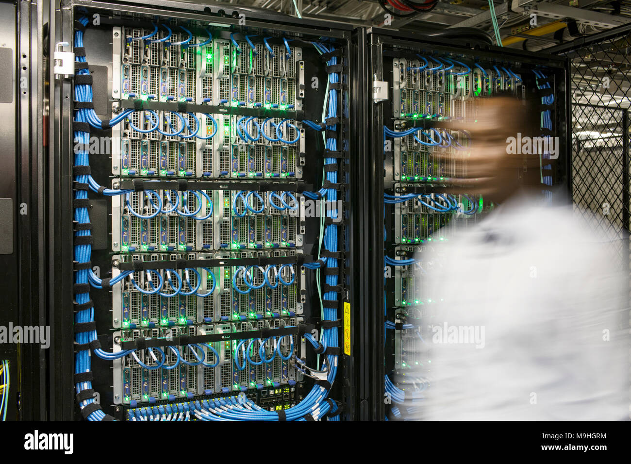 Technicien homme noir faisant des tests de diagnostic sur des serveurs informatiques dans la batterie de serveurs. Banque D'Images