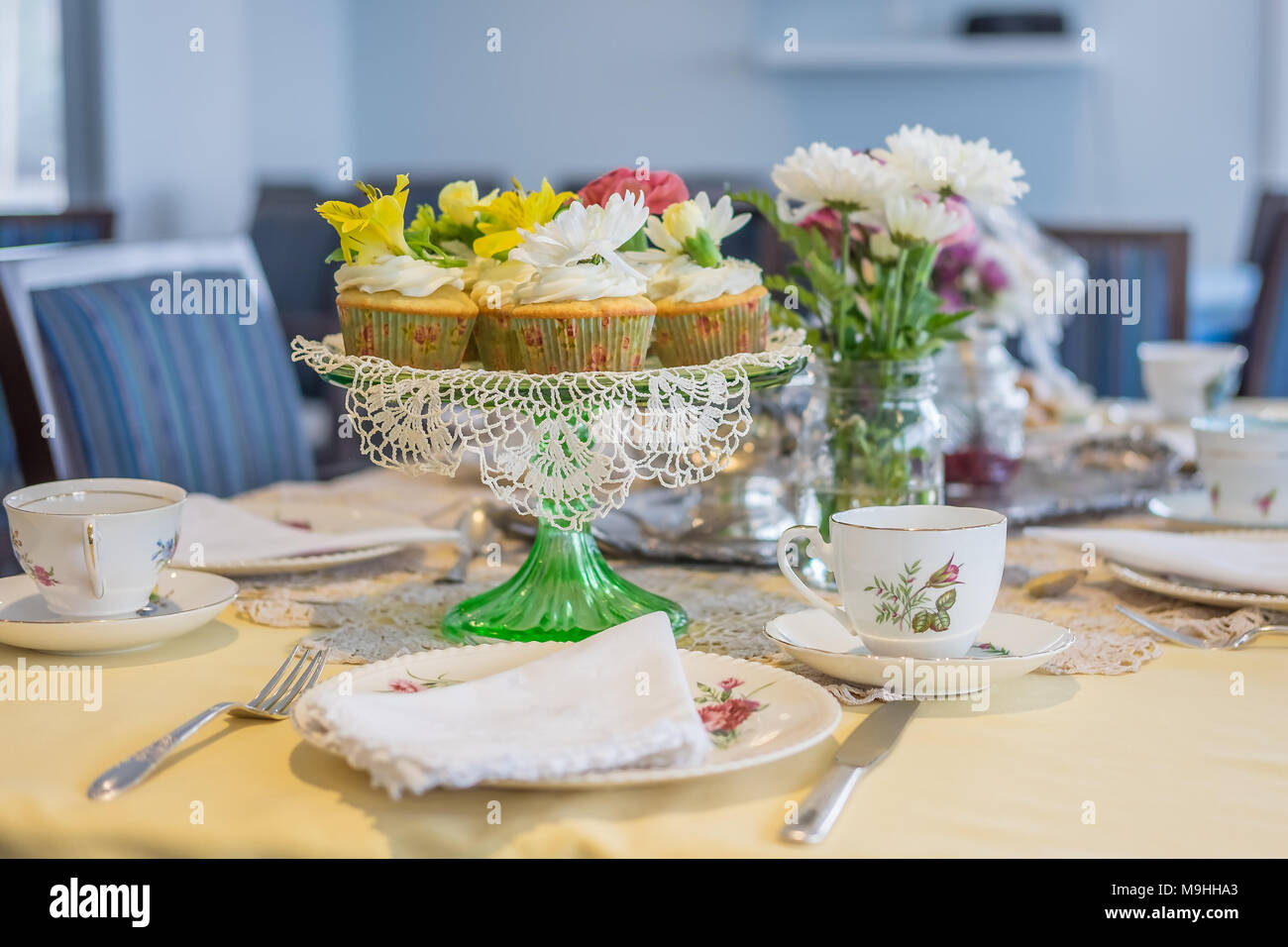Plateau de cupcakes à la vanille avec glaçage buttercream surmontées de magnifiques fleurs fraîches sur un magnifique tableau. Banque D'Images