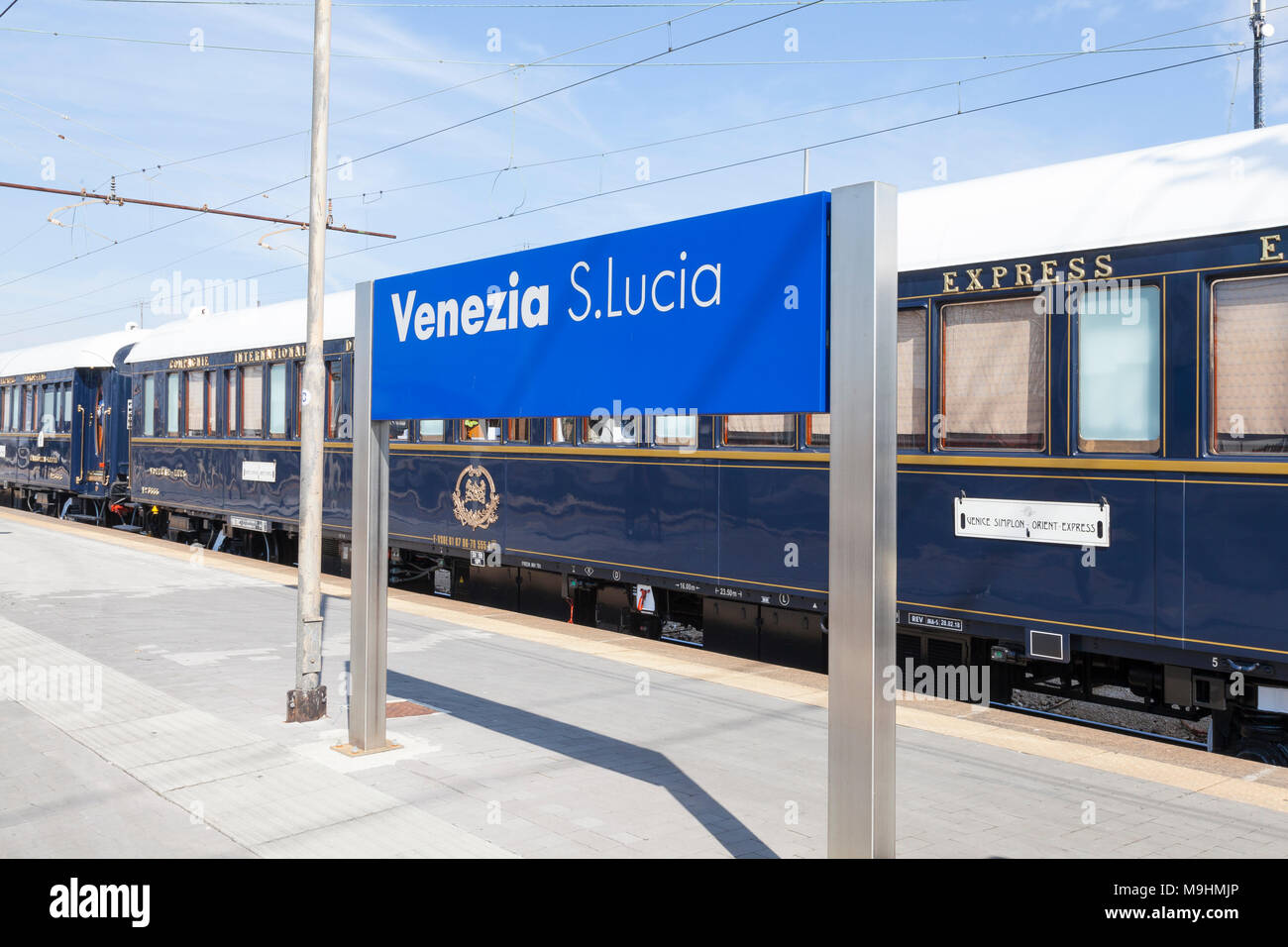 Le Venice Simplon Orient-Express trains de luxe à Venezia S gare Santa Lucia, Venise, Vénétie, Italie avec le signe de la gare au premier plan. Banque D'Images