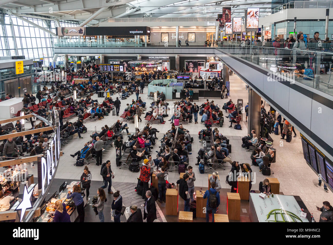 Les passagers qui attendent pour les vols à l'aéroport d'Heathrow, Terminal 5, manger, boire du café, assis. Magasins d'alimentation au détail et tout autour. Banque D'Images