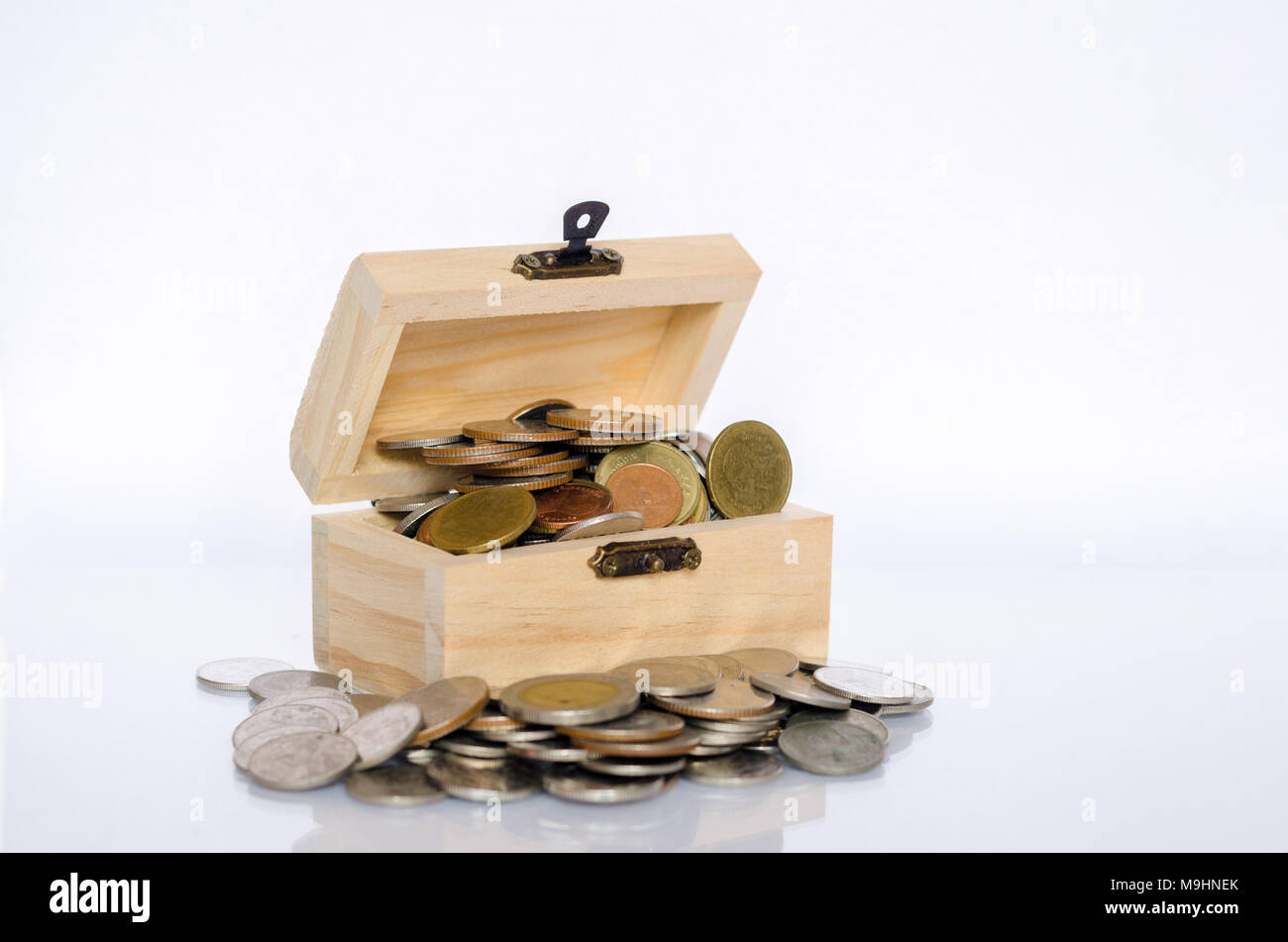 Couvercle intérieur avec pièce d'or, fond blanc, isoler la notion de richesse et de valeur pour l'argent. Banque D'Images