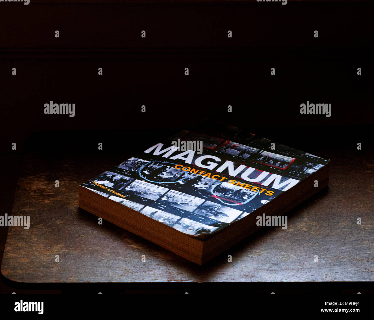 Livre de photographie sur table .Magnum, feuilles de contact, livre sur table en bois, éclairage latéral Banque D'Images