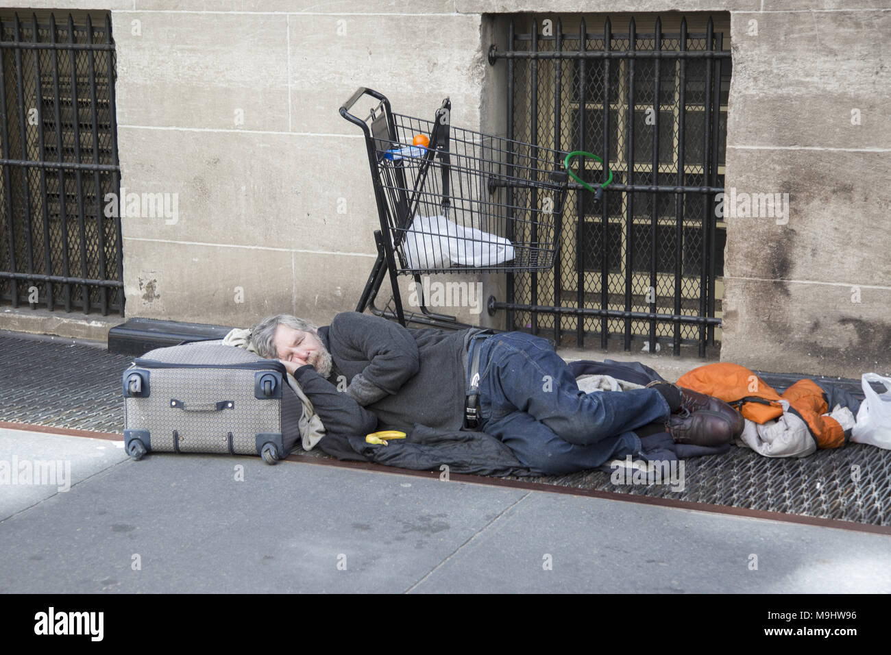 Sans-abri dort sur la rue à Midtown Manhattan, New York. Banque D'Images