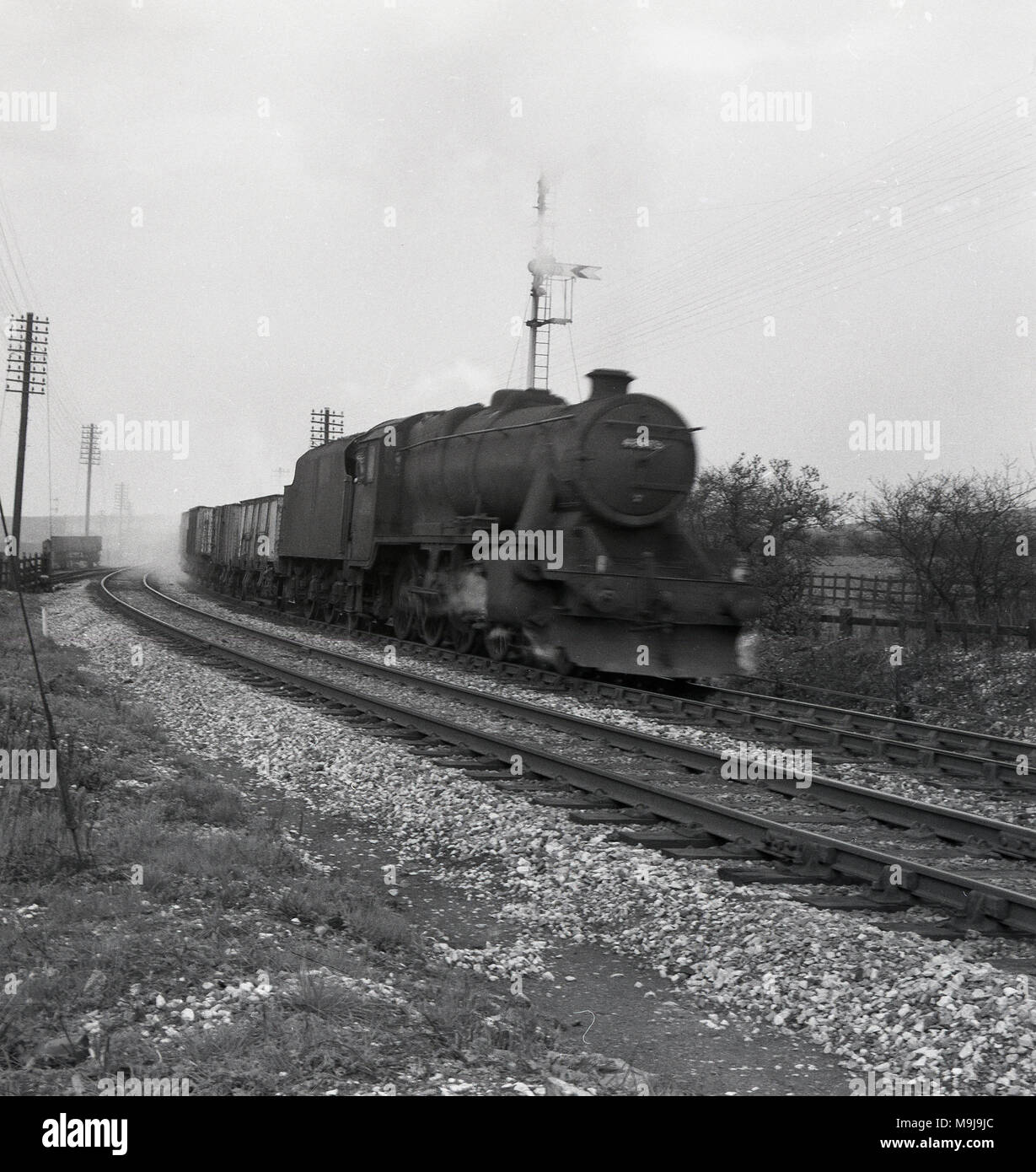 Années 1950, historique, d'une locomotive à vapeur avec chariots sur une voie de chemin de fer, England, UK. Banque D'Images