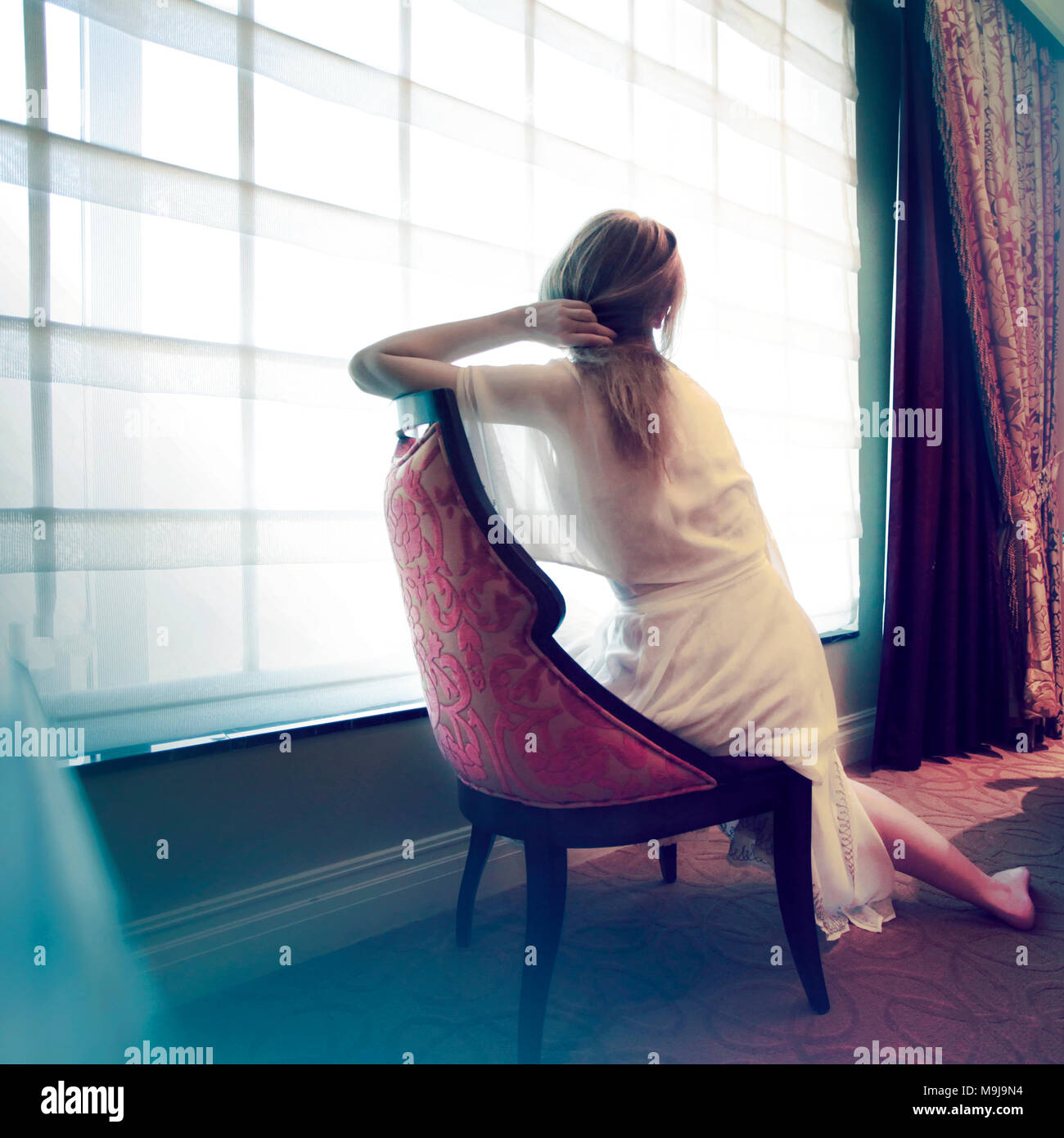 Femme assise dans une chambre Banque D'Images